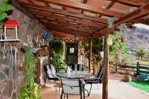 an outdoor patio with a table and chairs at La Casa de los Pinos Temisas in Temisas