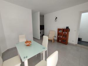 a dining room with a white table and white chairs at Casa Magec in Arinaga