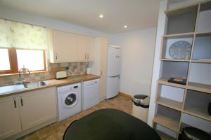 een keuken met een wastafel, een wasmachine en een droger bij Loch View Holiday Home, Fort William in Fort William