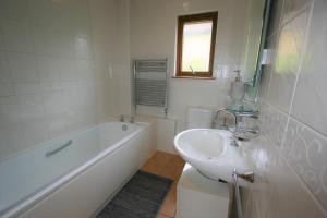 een badkamer met een wastafel, een bad en een toilet bij Loch View Holiday Home, Fort William in Fort William +2 foto's