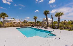 a swimming pool in a yard with palm trees at Starfish Cottage in Gulf Shores