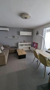 una sala de estar con un sofá y una mesa en Apt Rez de jardin piscine dans résidence, en Fréjus