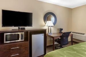 a hotel room with a microwave and a desk with a television at Quality Inn in Ontario
