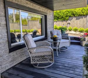 a patio with two chairs and a table and windows at By the Sea in Campbell River