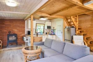 a living room with a couch and a kitchen at Domek Omin in Omin