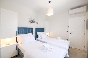 two beds in a room with white and blue at CROWONDER Villa Bura with Heated Swimming Pool and Jacuzzi in Privlaka +43 photos