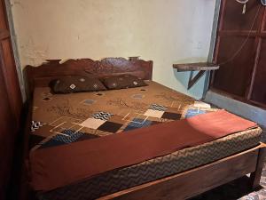 a bed with a quilt and pillows on it at Pongo Guest House & only jungle trekking whit us in Bukit Lawang