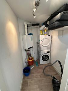 a laundry room with a washing machine and a washer at Appartement 'Zeeblick' in Burgerbrug