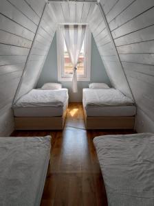 Habitación en el ático con 2 camas y ventana en Nowa Siesta Camp Łeba, en Nowęcin