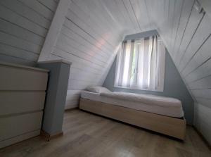 Un dormitorio pequeño con una cama y una ventana. en Nowa Siesta Camp Łeba, en Nowęcin 2 fotos más
