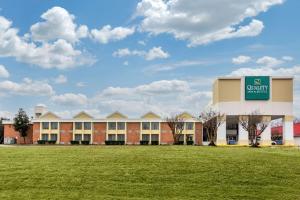 een gebouw met een groen bord bovenop een veld bij Quality Inn & Suites Ruther Glen in Ruther Glen
