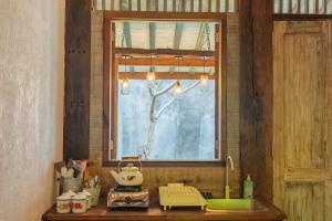 a kitchen counter with a sink and a window at Singgah Ndalem - wooden house Jogja in Yogyakarta +12 photos