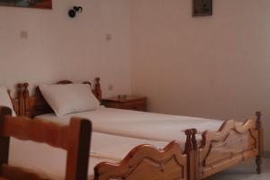 a bedroom with a wooden bed and two night stands at ΜΑΧΗ Ενοικιαζόμενα δωμάτια in Mythimna
