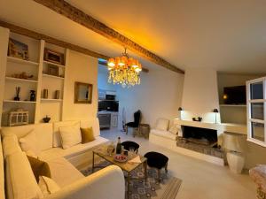 ein Wohnzimmer mit einer Couch und einem Kronleuchter in der Unterkunft Maison Saint Tropez in Saint-Tropez