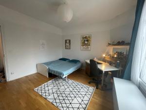 a room with a bed and a desk in it at Maison Chic familiale avec Jardin in Gennevilliers