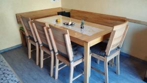Una mesa y sillas de madera con un plato de comida encima. en Ferienhaus am Bach, en Oberdiebach