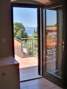an open door to a balcony with a view of the ocean at Appartement Melchior - Turm Krk in Sveti Vid-Miholjice