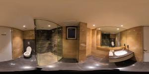 a bathroom with two toilets and a sink and mirrors at Kyriad Hotel Gulbarga by OTHPL in Gulbarga +64 photos