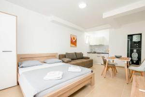 a bedroom with a bed and a couch and a table at Apartments Milivojevic in Bar