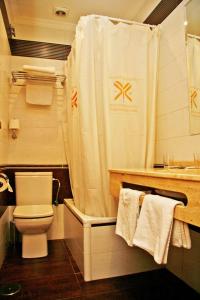 y baño con aseo y cortina de ducha. en Hostal Victoria I, en Madrid