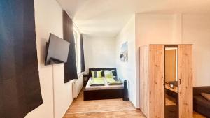 a small room with a bed with yellow pillows at Richter Apartments Finsterwalde 4 in Finsterwalde