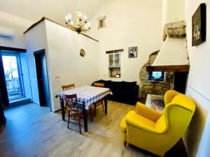 a living room with a table and yellow chairs at Authentic stone house Miro in Rajki