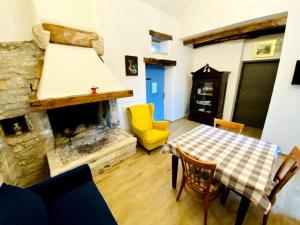 a living room with a table and a fireplace at Authentic stone house Miro in Rajki