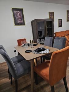 a dining room table and chairs with wine glasses at Ema HILLS in Vranje +10 photos