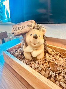 a wooden bear with a welcome sign on its head at Richter Apartments Finsterwalde 4 in Finsterwalde