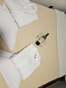 a pile of white towels and a bottle of wine at Ema HILLS in Vranje