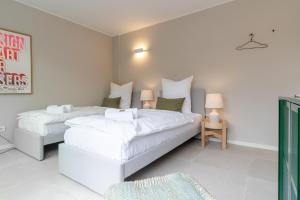 two beds in a room with white walls at HOMEFY - Luxury Bungalow in Ratingen +29 photos