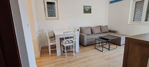 a living room with a couch and a table at Guest House Pikala in Goveđari