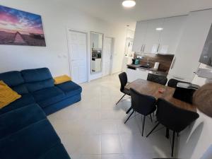 a living room with a blue couch and a table at Apartment sea Lux in Povljana