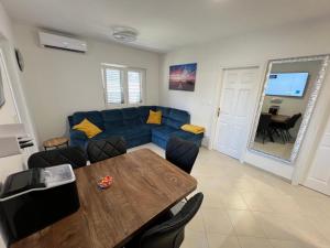 a living room with a blue couch and a wooden table at Apartment sea Lux in Povljana