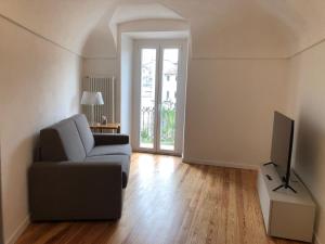a living room with a couch and a television at Gusterhouse Castellazzo in Ivrea