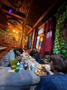 a group of people sitting at a table eating food at Yamuna Guest House Tosh in Tosh