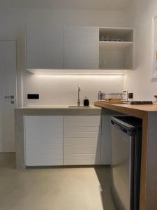 a kitchen with white cabinets and a sink at Hideaway Syros in Megas Gialos - Nites