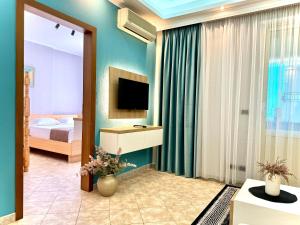 un salon avec une télévision et une chambre dans l'établissement Seaside Beach Apartments - by EKA Luxury Apartments, à Durrës