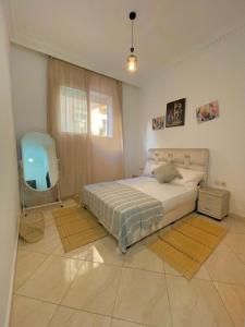 a bedroom with a bed with a mirror and a window at Résidence jawharat mogador in Essaouira
