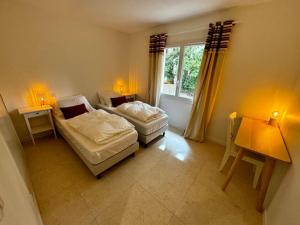 a bedroom with two beds and a window at T3 avec jardin - mer, soleil et tout à pied in Cavalaire-sur-Mer