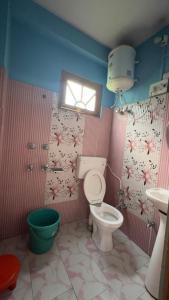 a bathroom with a toilet and a sink and a window at Yamuna Guest House Tosh in Tosh