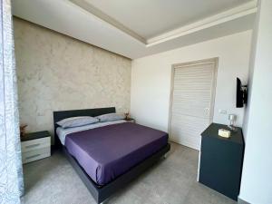 a bedroom with a bed with purple sheets and a window at Flowers Apartments in Marineo