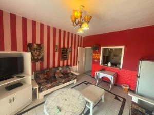 a living room with a red and white striped wall at Marina 2 chalet lake front in El Alamein +15 photos