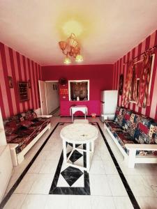 a living room with pink walls and a table at Marina 2 chalet lake front in El Alamein
