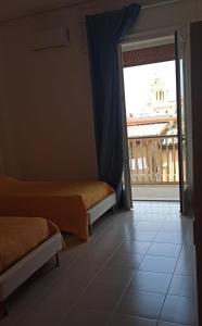 a room with two beds and a large window at La Camera sul Corso in Grammichele
