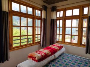 SissuBros Hostel & Cafe, Sissu的配有2扇窗户的客房内的1张床
