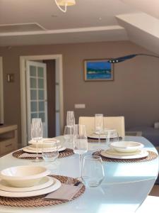 a table with wine glasses and plates on it at Jaukus butas prie jūros in Klaipėda