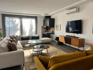 a living room with couches and a flat screen tv at Villa prestige in Essaouira