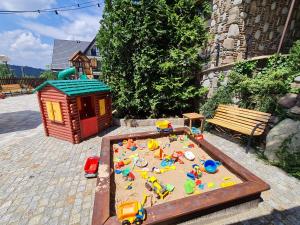 a toy sandbox and a play house in a backyard at Willa Roztoka & SPA - idealne miejsce dla Twojej rodziny in Bukowina Tatrzańska