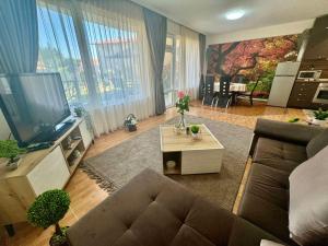 a living room with a couch and a flat screen tv at Cozy Seaside Getaway One Bedroom Apartment Moni in Sveti Vlas in Sveti Vlas